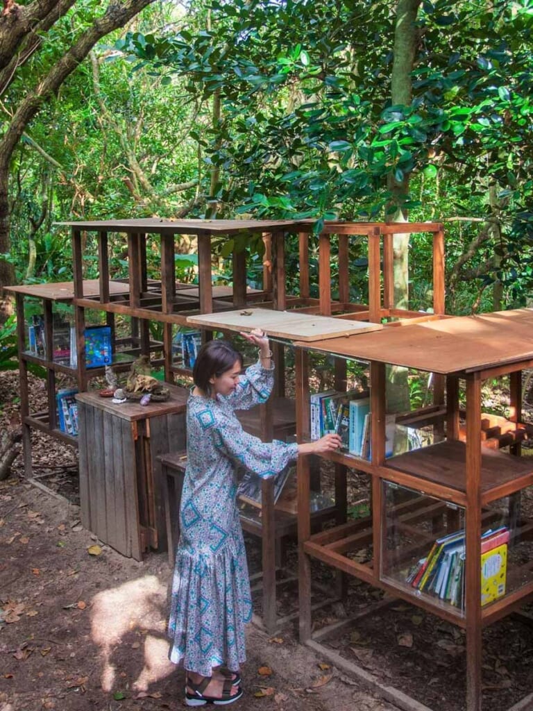 woman looking through outdoor library at Hoshino hotel, Okinawa