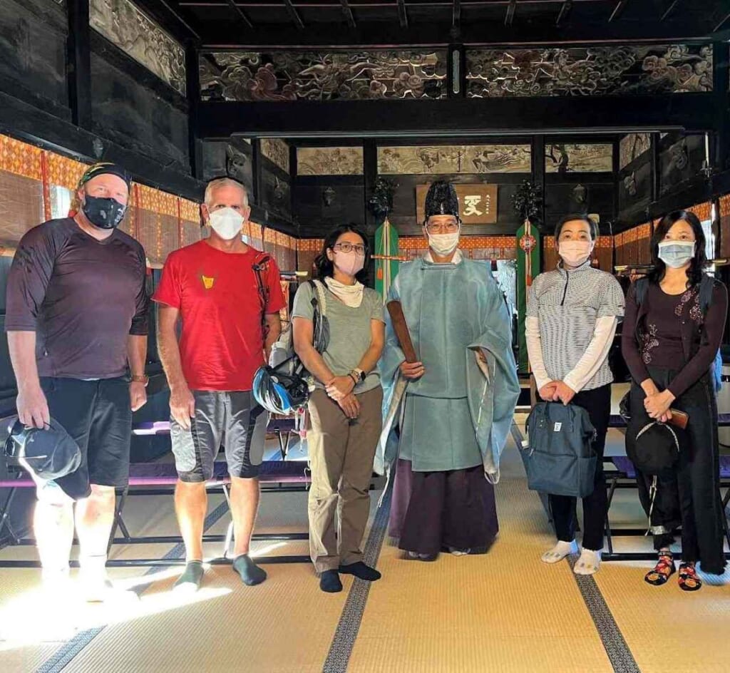 Priest with visitors at Aoi Aso Shrine in Kumamoto.