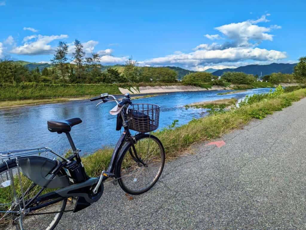 Rental bicycle by a river on a sunny day in Azumino
