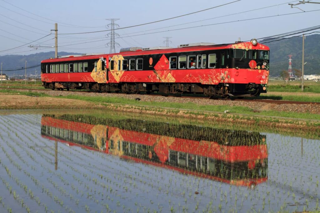 red train in japanese countryside