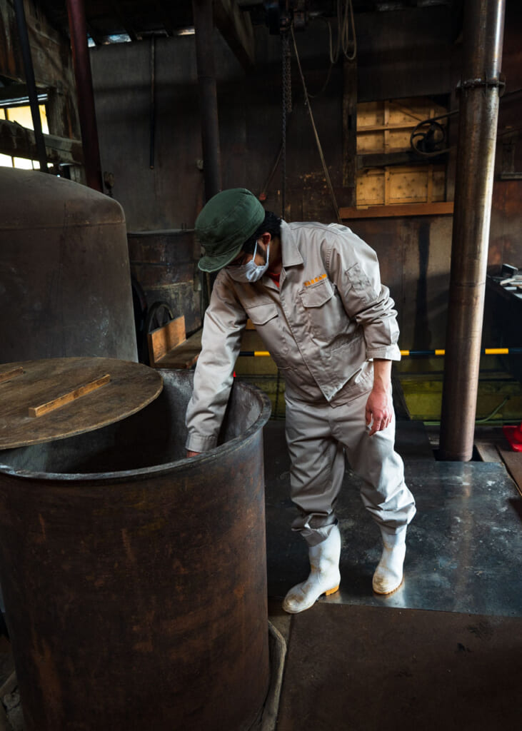 Worker checking the soy sauce brewing process in Japan