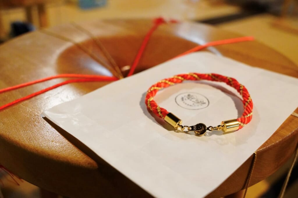 A finished kumihimo bracelet on a marudai round braiding table in Iga