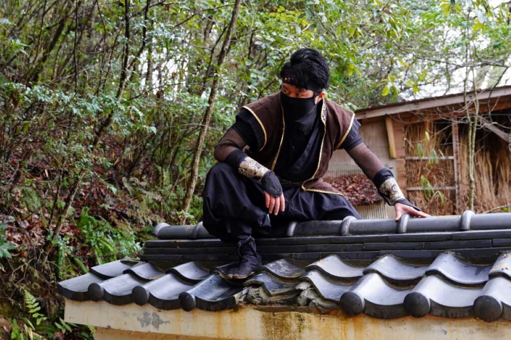 Ninja staff climbing a roof at Koka Ninja Village in Japan