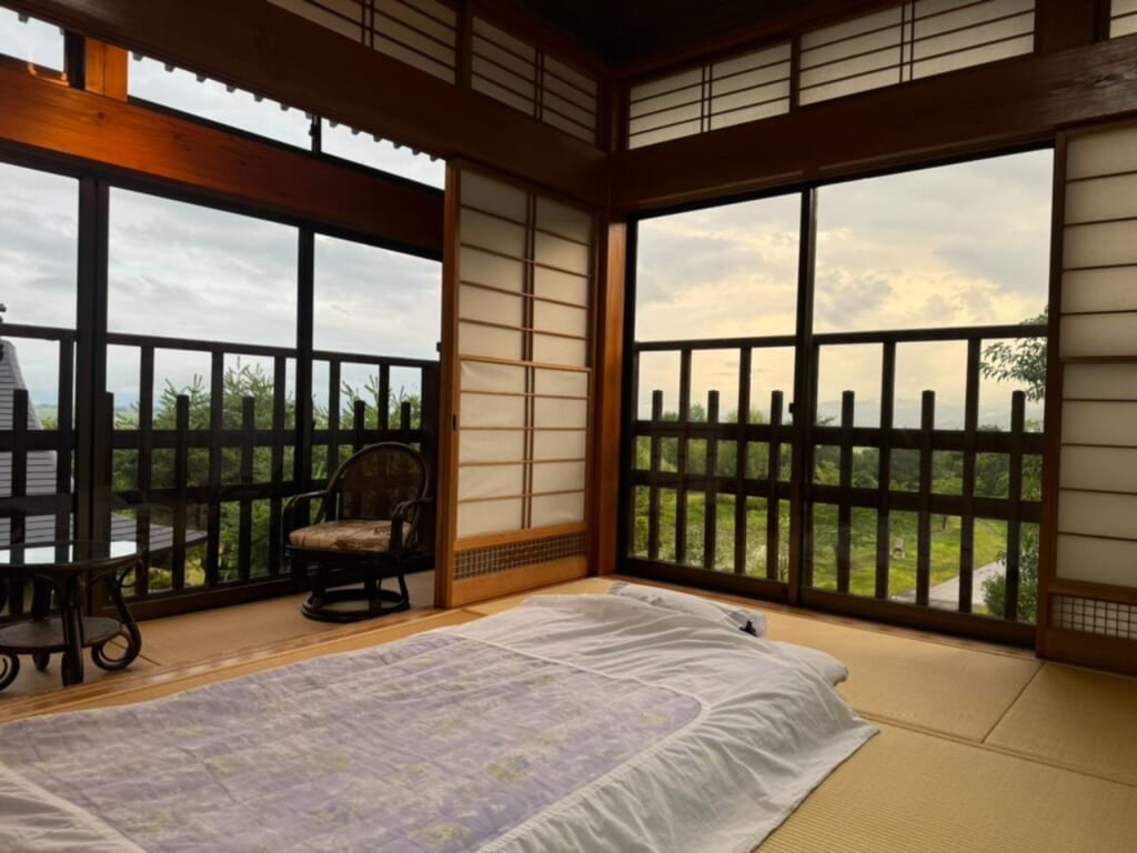 A traditional Japanese tatami room and futon warmly lit by the sunset
