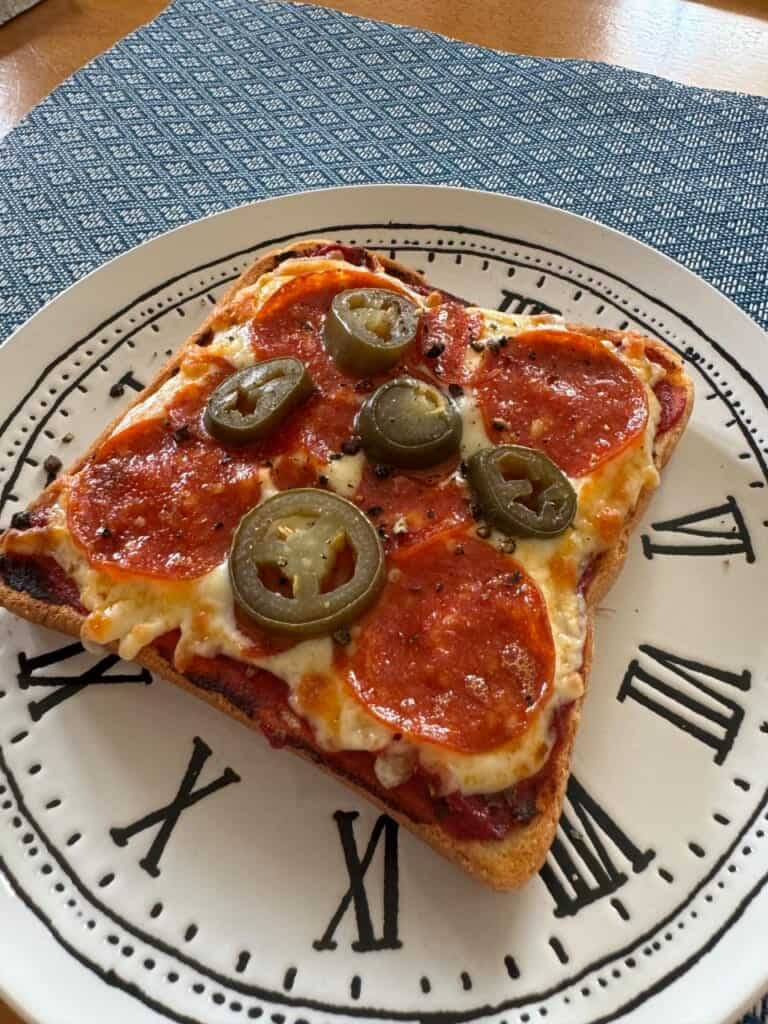 A piece of toast topped with pizza toppings