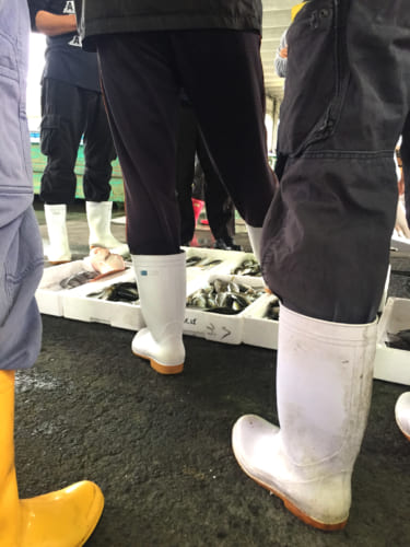 Marché aux poissons de Kamae : bottes des pêcheurs et poissons prêts à la vente