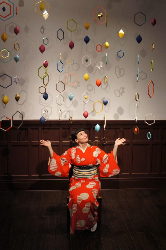 Clémentine posant au milieu de mobiles modernes et colorés