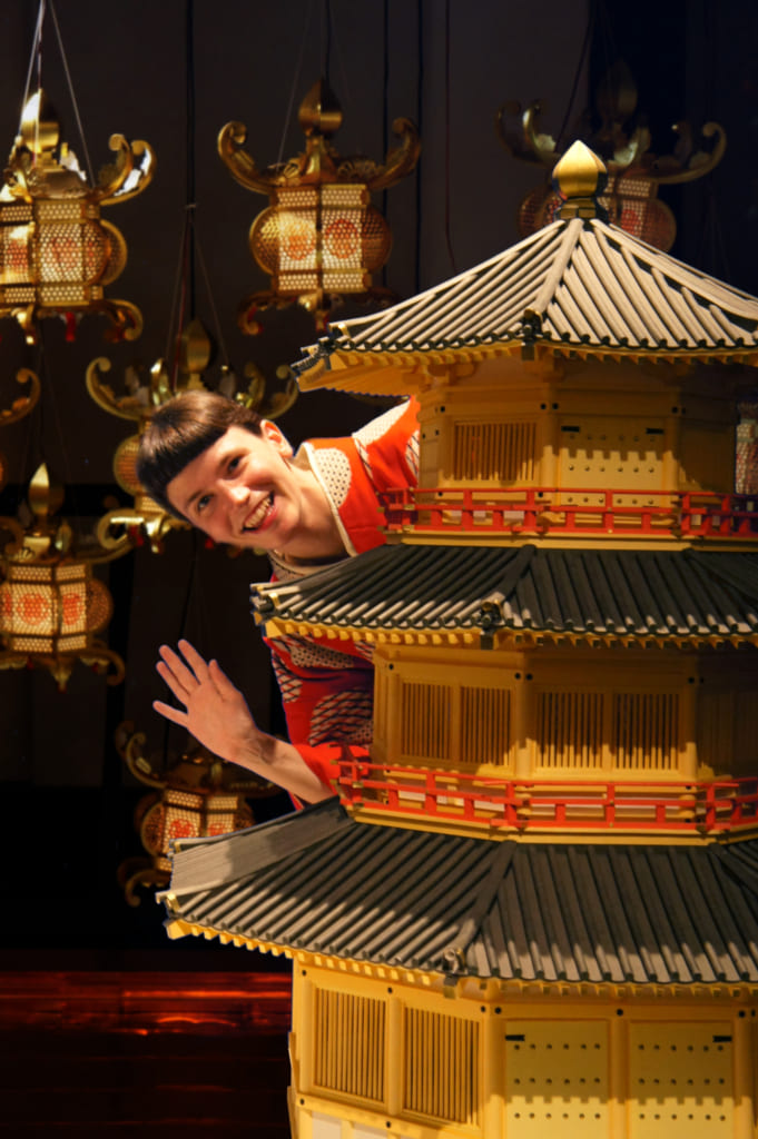 Clémentine posant à côté d'une reproduction du château de Kikuchi, fond de lanternes incrusté