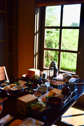 Le copieux petit déjeuner, servi sur une table éclairée par la lumière matinale au Ryokan Konomama