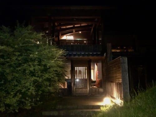 Bâtiment du ryokan Konomama vu de nuit, les lumières sont allumées à l'intérieur