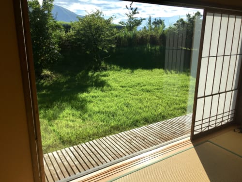 Grande baie vitrée ouverte sur le jardin verdoyant au Ryokan Konomama