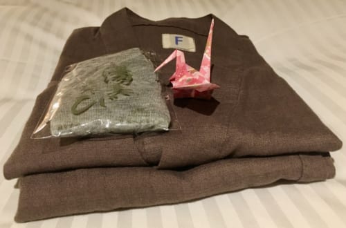 Pyjama plié, disposé sur le lit avec une grue en origami