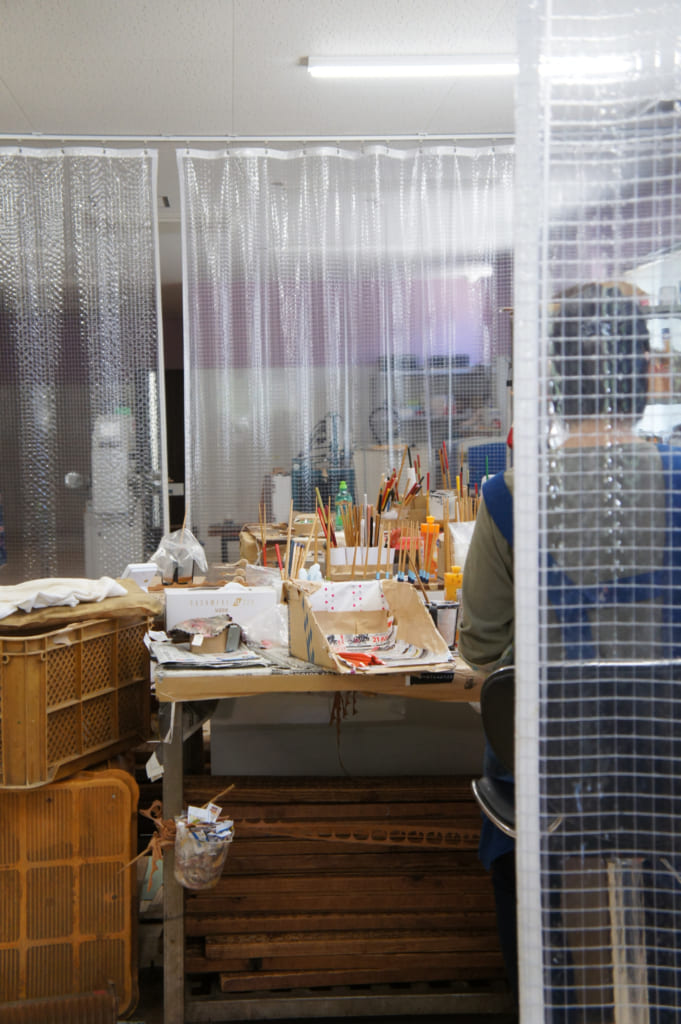 Ouvrière travaillant à la peinture des baguettes dans l'atelier de Yamachiku