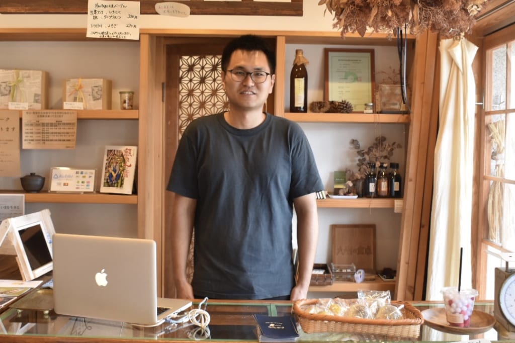 Vendeur debout derrière le comptoir de l'épicerie Kyushu no Shokutaku