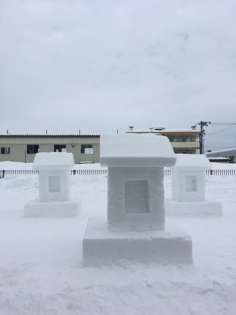 Sculptures de temples et chiens dans la neige durant le festival Inukko Matsuri