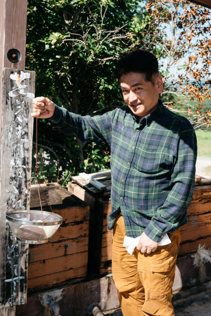 Hirose-san portant le panier d'aliments cuits à la vapeur de l'onsen