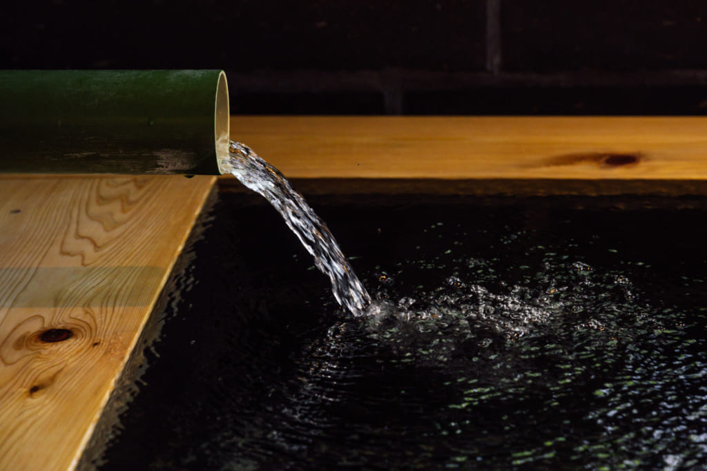 Gros plan sur l'eau qui coule dans le bassin en bois