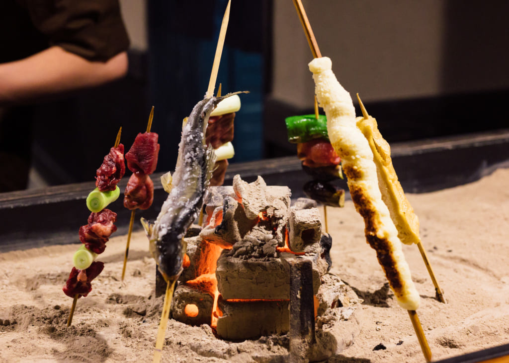 Brochettes, en train de griller autour de charbons ardents, à Kumamoto