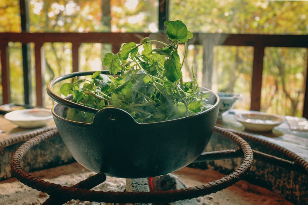 Une soupe de cresson entrain de cuire au dessus du brasier