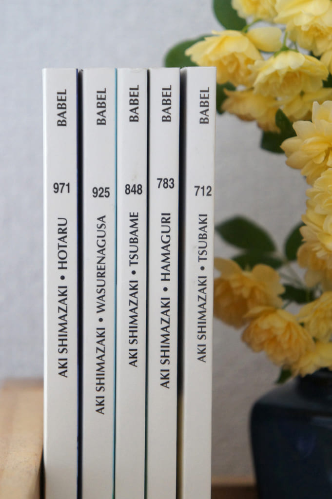 Les livres d'Aki Shimazaki à côté de fleurs jaunes