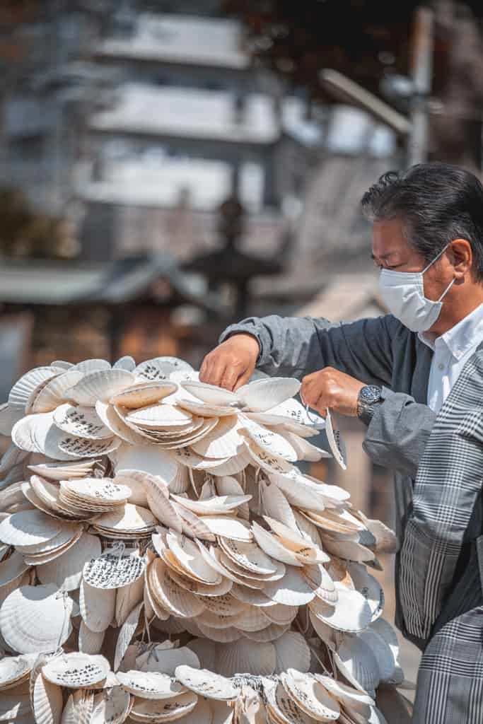Un homme écrivant ses souhaits sur un ema, sanctuaire Himejima, Osaka