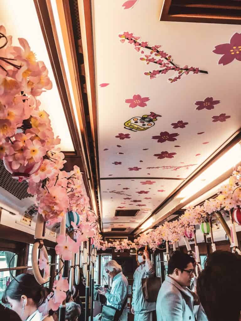 un tramway japonais décoré aux couleurs des cerisiers en fleur