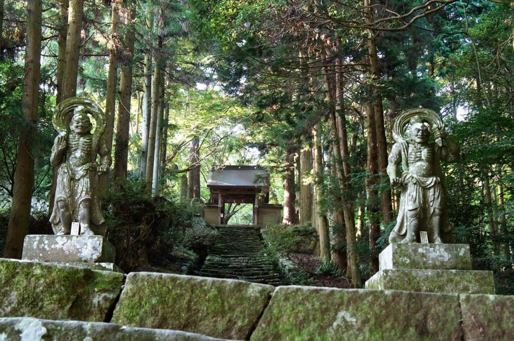 Statues nio de pierre bordant l'escalier devant le temple Futago-ji à Oita