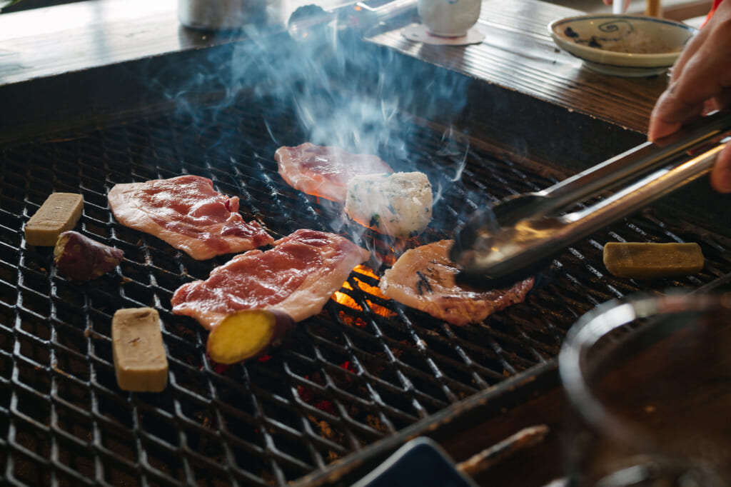 des tranches de porc entrain de cuire sur un barbecue japonais