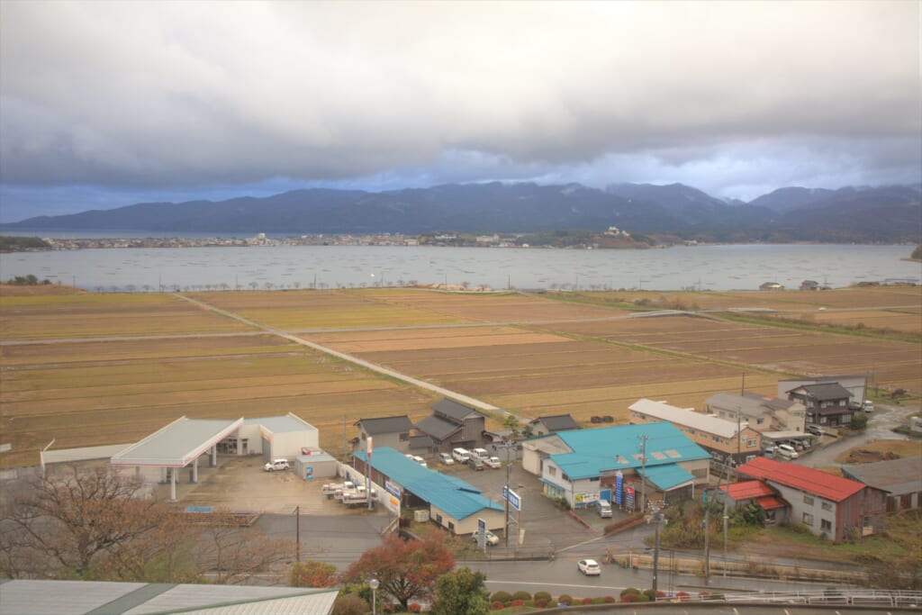 Vue sur les champs et le lac Kamo depuis le Ryotsu Yamaki Hotel