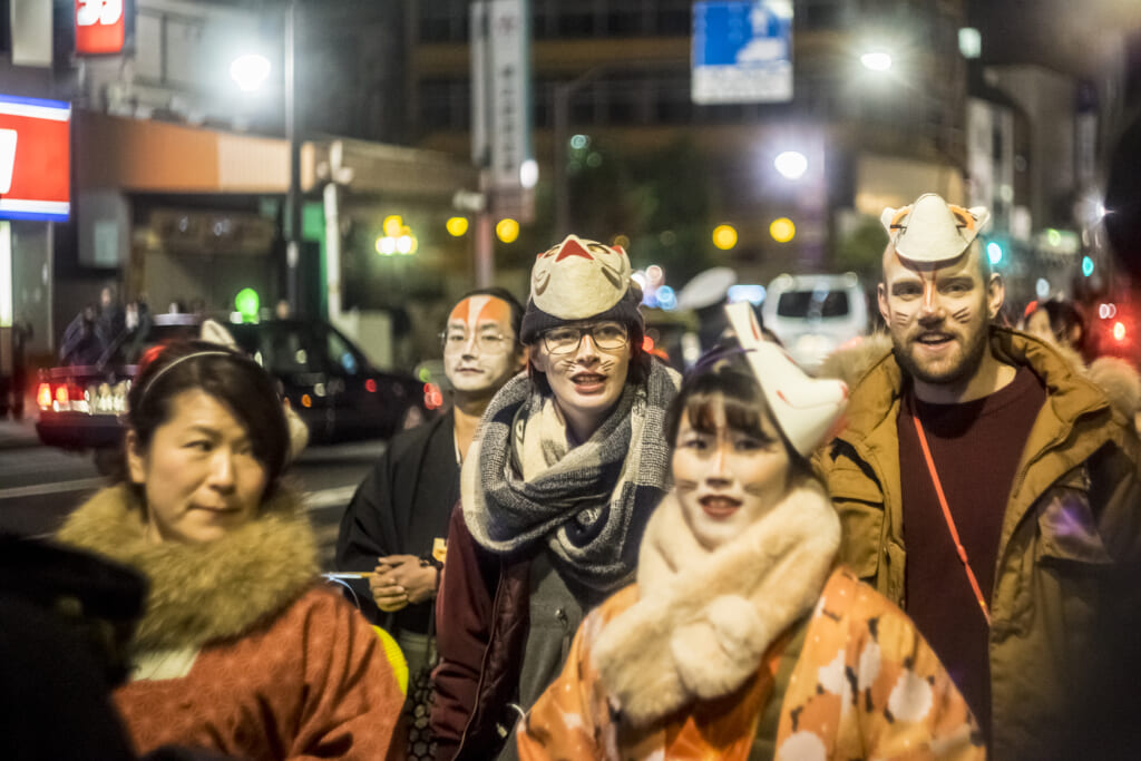 des étrangers participant à la parade du nouvel an japonais en l'honneur du dieu renard inari