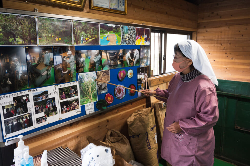 Productrice de tsubaki expliquant le processus traditionnel de production d'huile de camélia