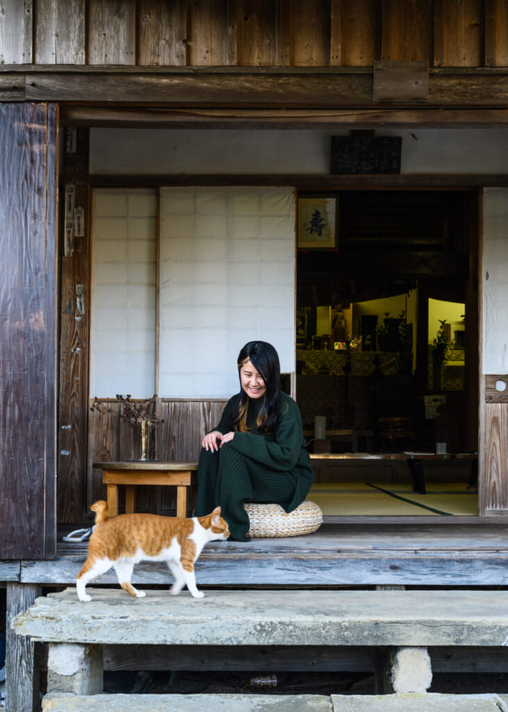 Chat roux et blanc et femme japonaise devant un temple bouddhiste