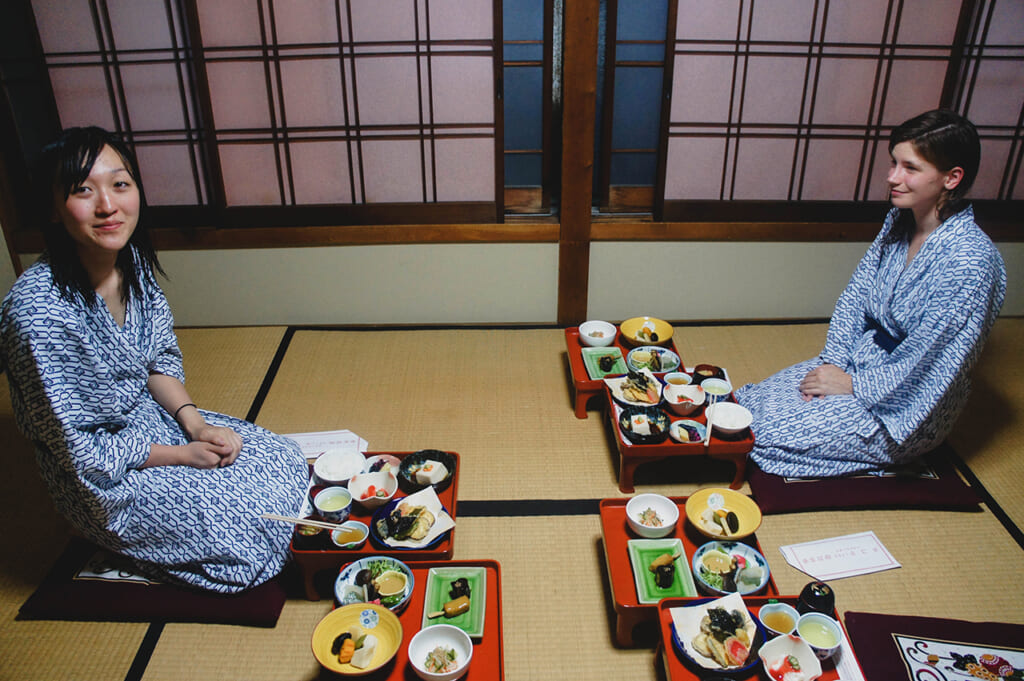 Deux personnes en yukata, devant un repas de shojin ryori servi dans une chambre japonaise