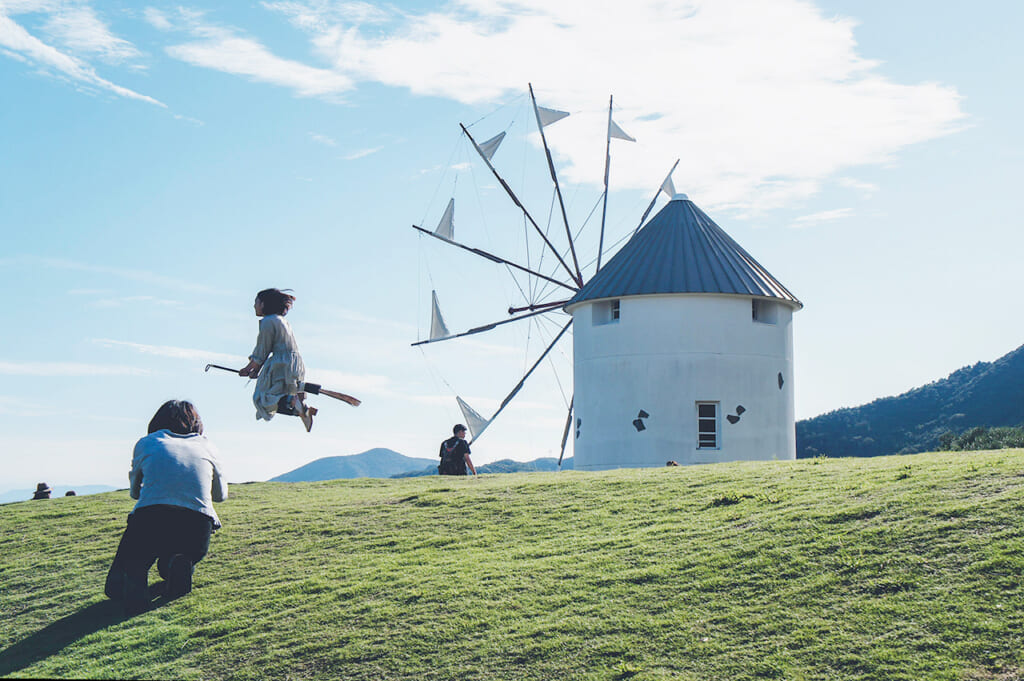 Moulin grec sur l'île de Shodoshima devant lequel une jeune fille semble voler sur un balais