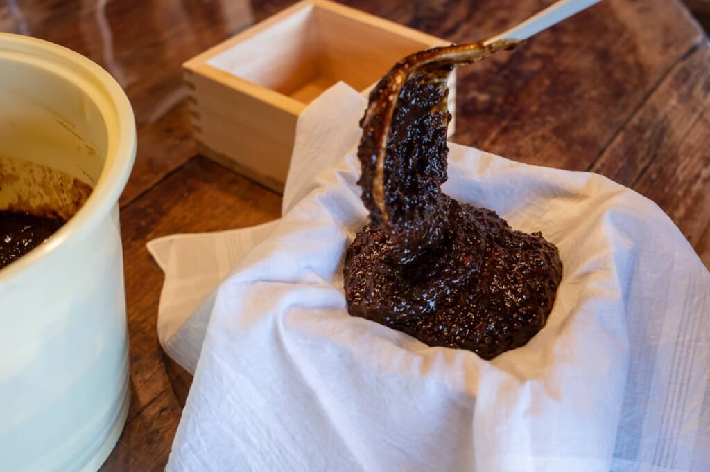 Pour obtenir de la sauce soja, il faut extraite la sauce de la pâte en pressant fortement