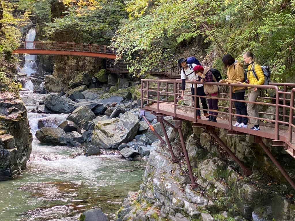 Randonneurs près d'une cascade dans la vallée de Hida au Japon