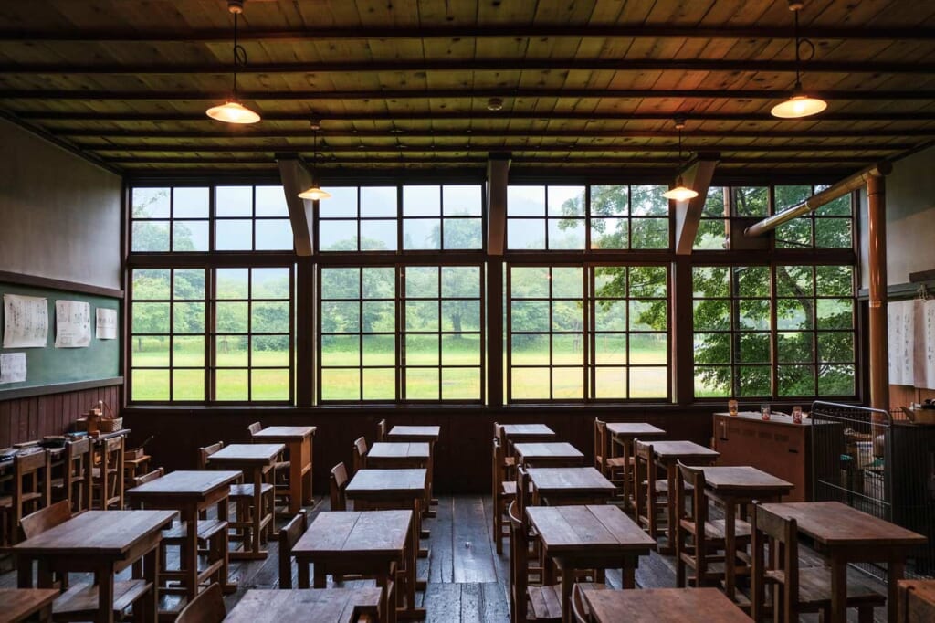 Salle de classe d'une ancienne école japonaise à la campagne, avec des pupitre des bois et un harmonium