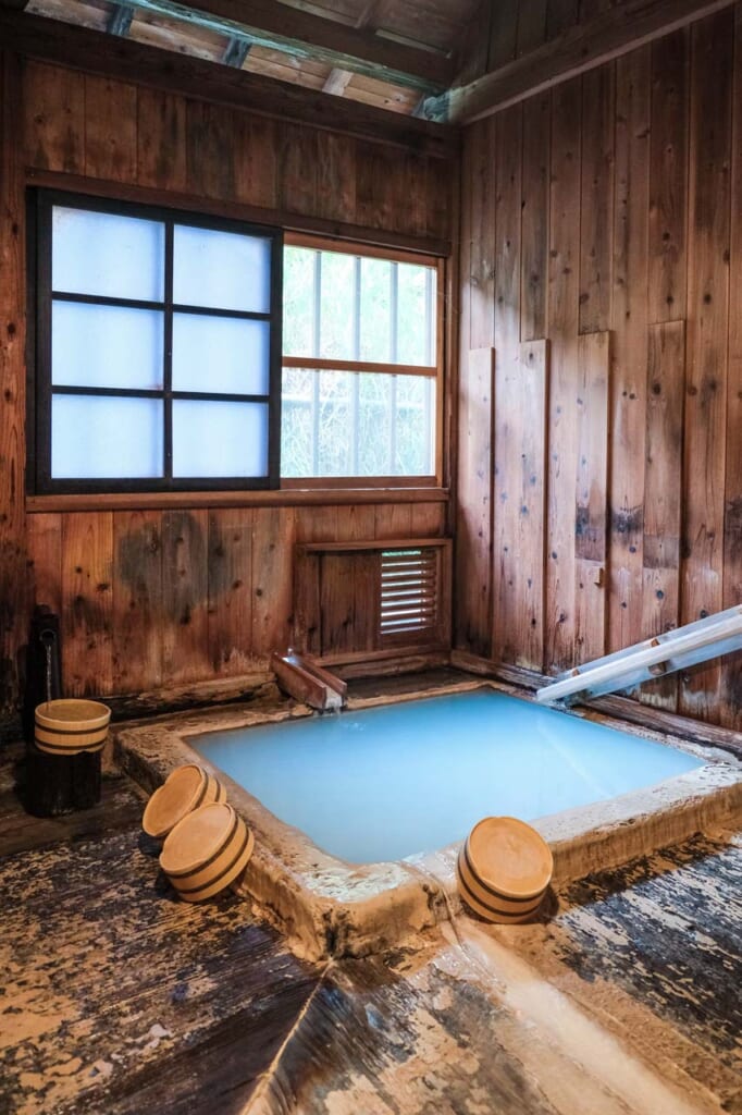 Onsen bleu laiteux en intérieur, dans un bâtiment en bois