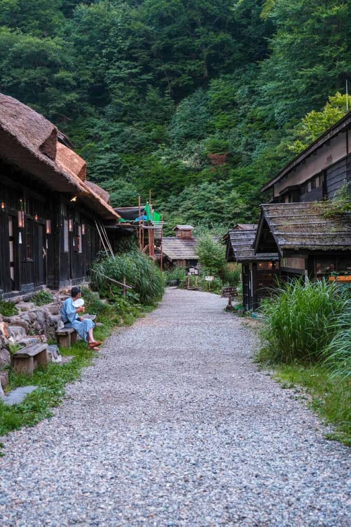 L'allée de Tsurunoyu Onsen à Nyuto, bordée de bâtiments en bois au toit de chaume