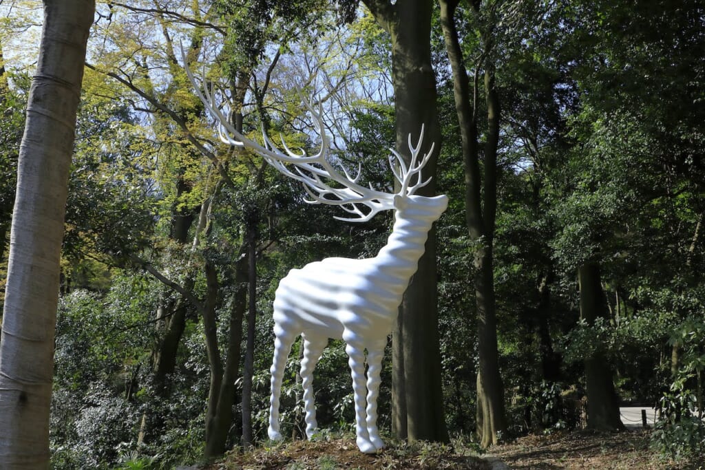sculpture d'un cerf blanc en forêt 