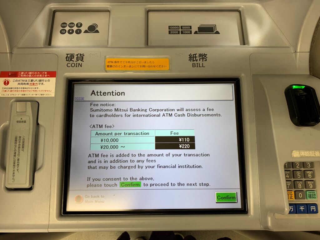 écran d'un distributeur au Japon indiquant les frais de retrait pour les yens
