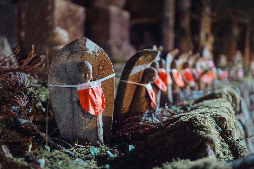 De petites statues bouddhistes dans un cimetierre japonais en pleine nuit