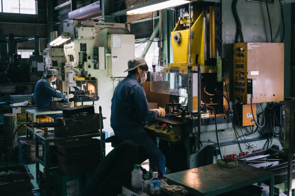 un artisan s'affaire sur des machines au Japon