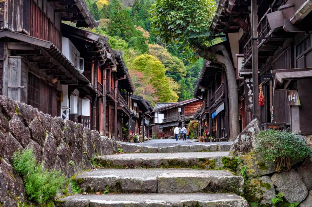 escaliers en pierre devant un chemin bordé de maisons en bois sur le Nakasendo