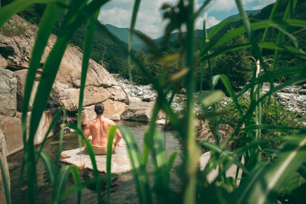 homme assis dans une bain thermale de montagne à Okuhida Onsen-go