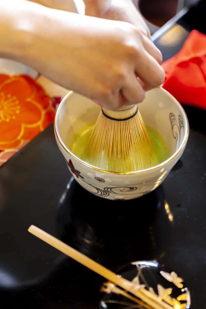 mélange de thé matcha dans un bol lors de la cérémonie du thé