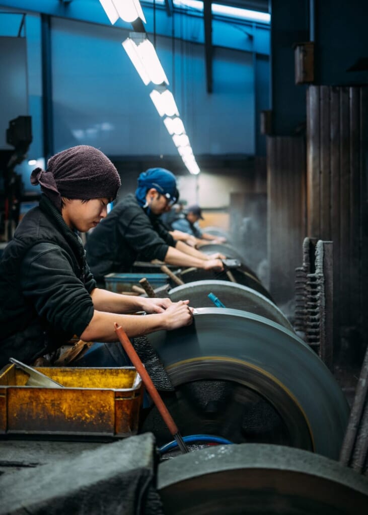 Des artisans affutent les lames de couteaux qu'ils viennent de forger