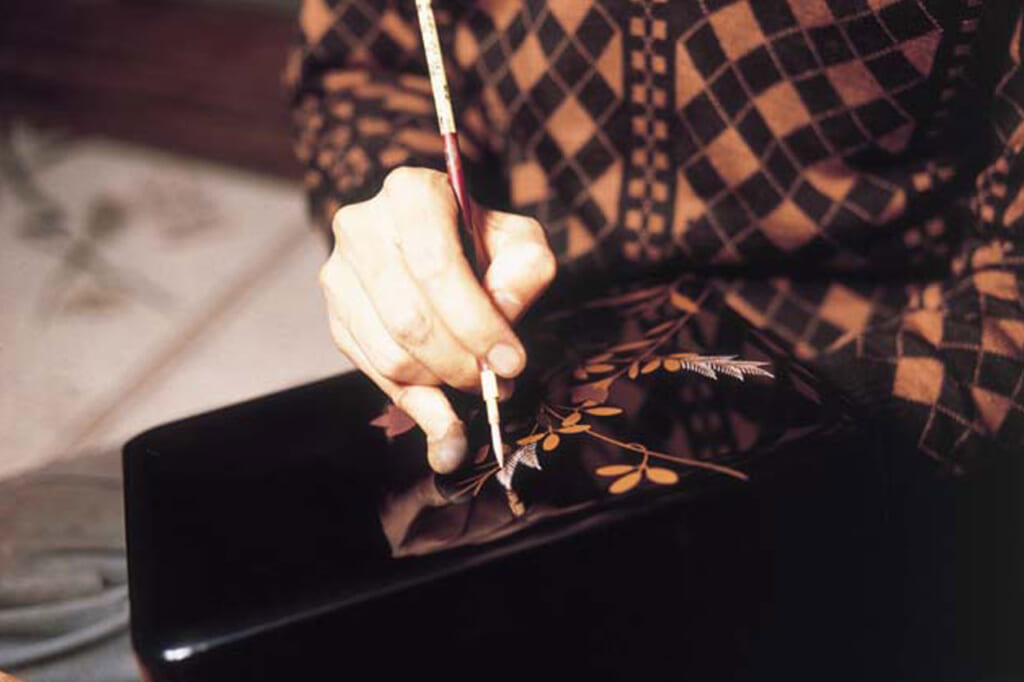 Artisan peignant une laque japonaise