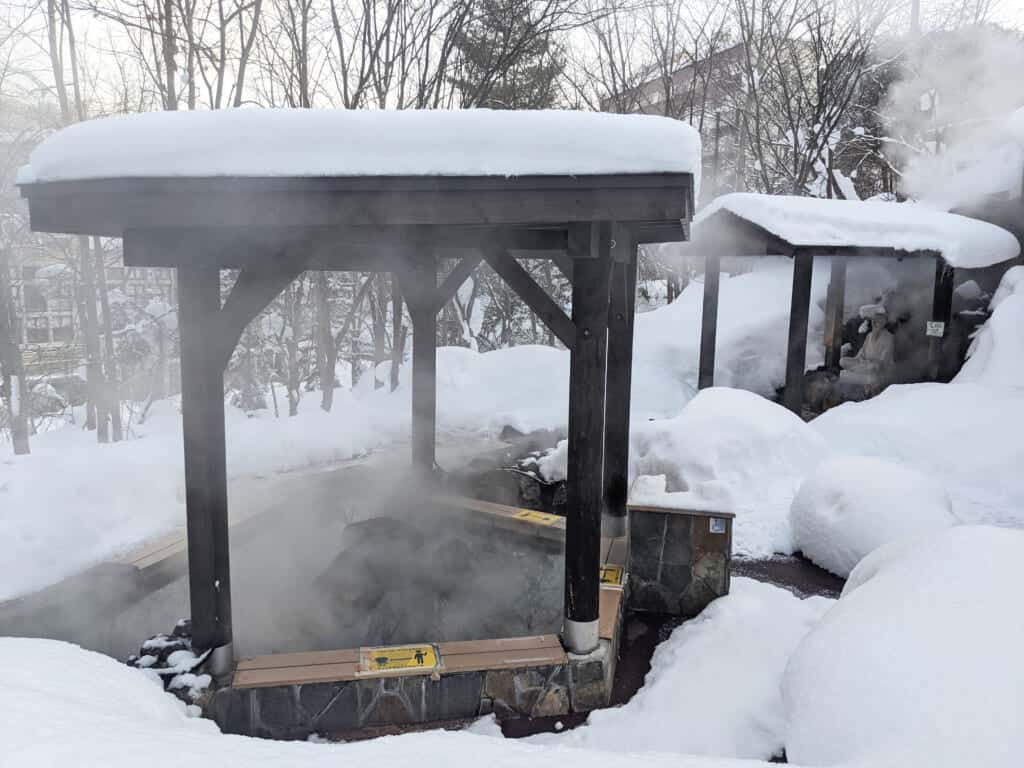 Bain de pied onsen, fumant au milieu de la neige
