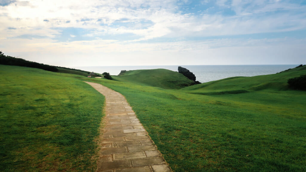Pelouse verte et chemin menant à Oni no Ashiato, à Iki